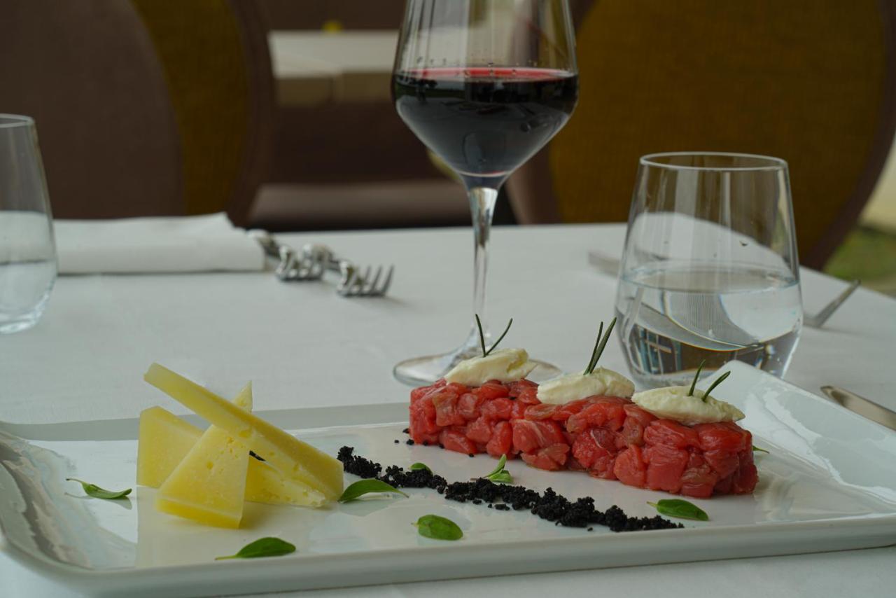 Pisa Tower Plaza Otel Dış mekan fotoğraf A glass of red wine with a plate of tartar